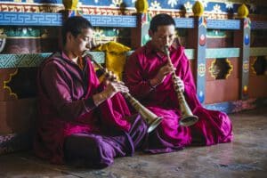 Asian monks playing instruments on temple floor